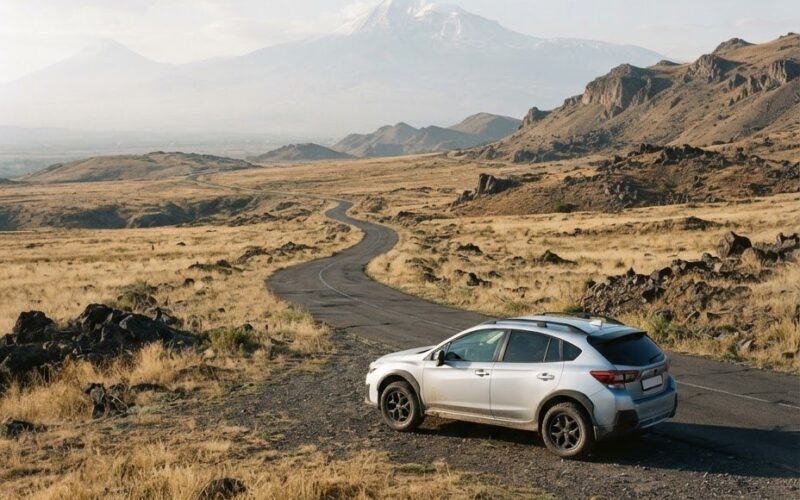 Silver SUV on a highland road in Armenia with Mount Ararat on the horizon