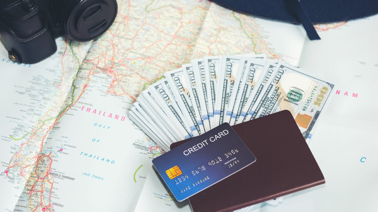 Banknotes, a bank card and a passport on a travel map